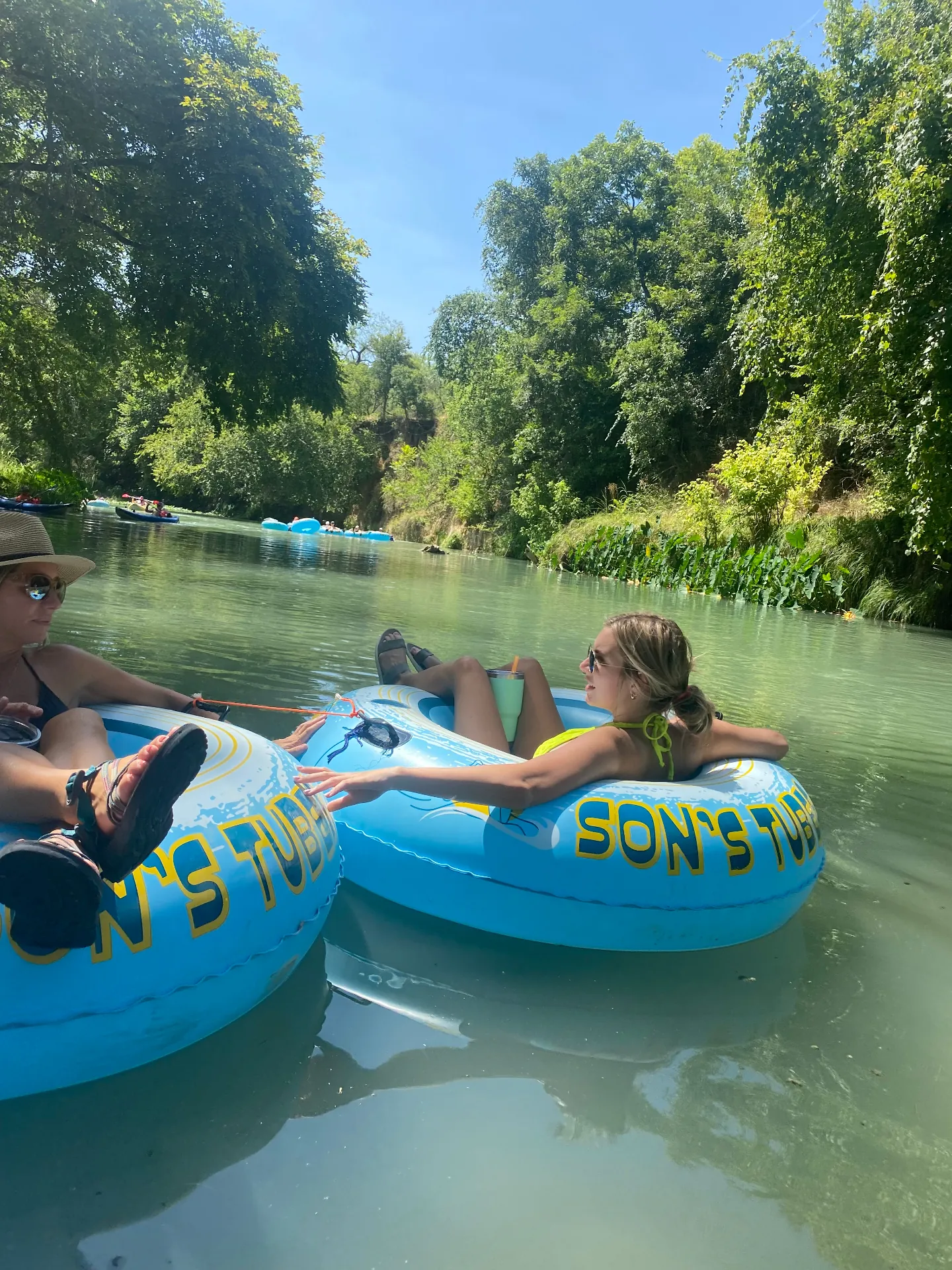 Women relaxing on tubes in the river
